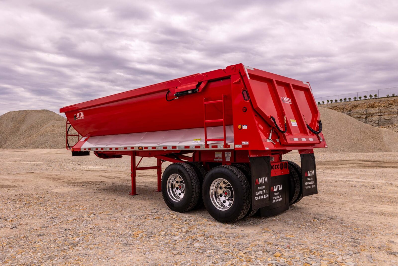 Red quarter-frame end-dump trailer in a quarry