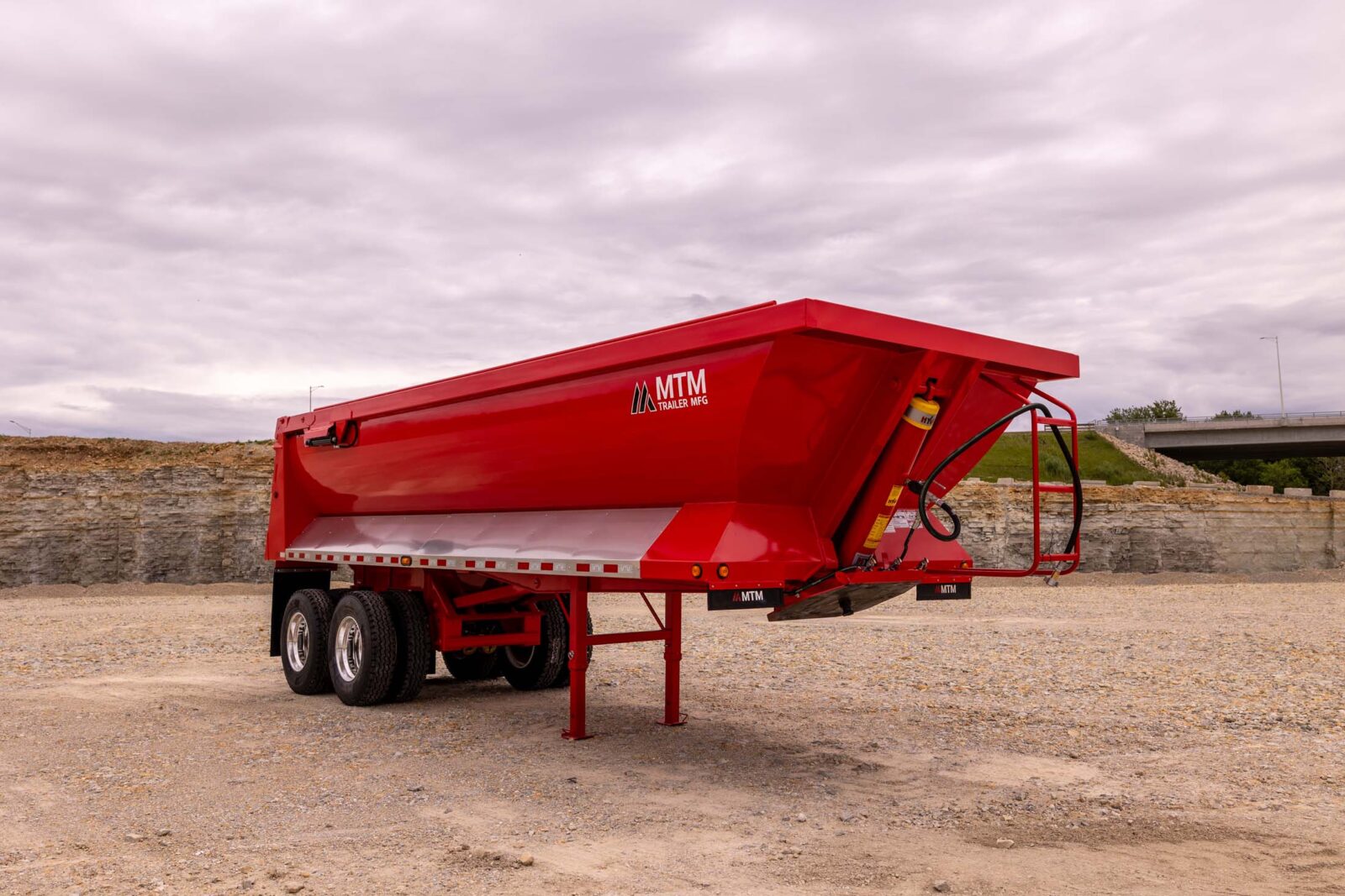 Red quarter-frame end-dump trailer in a quarry