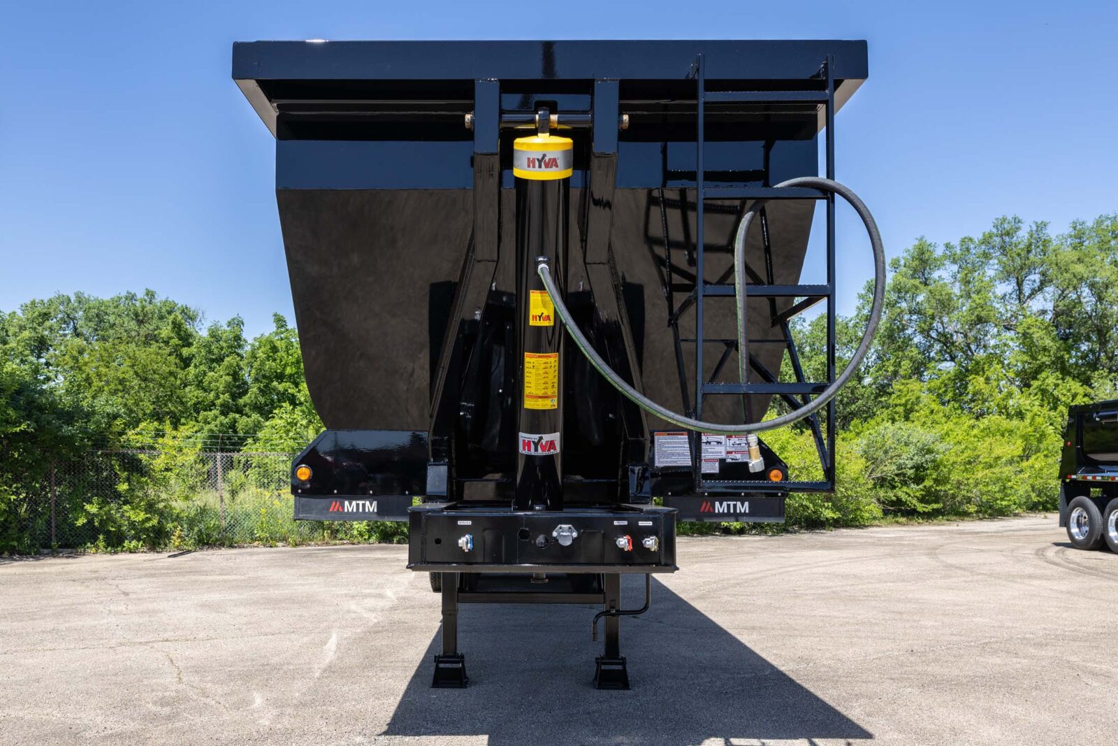black heavy-duty full-frame MTM end-dump trailer front end