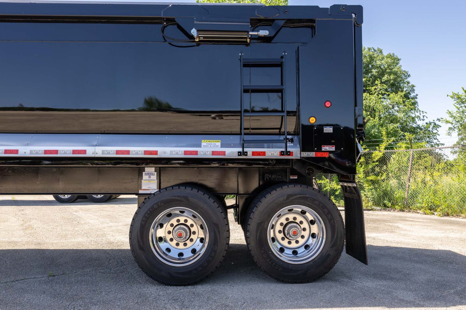 black heavy-duty full-frame MTM end-dump trailer back end