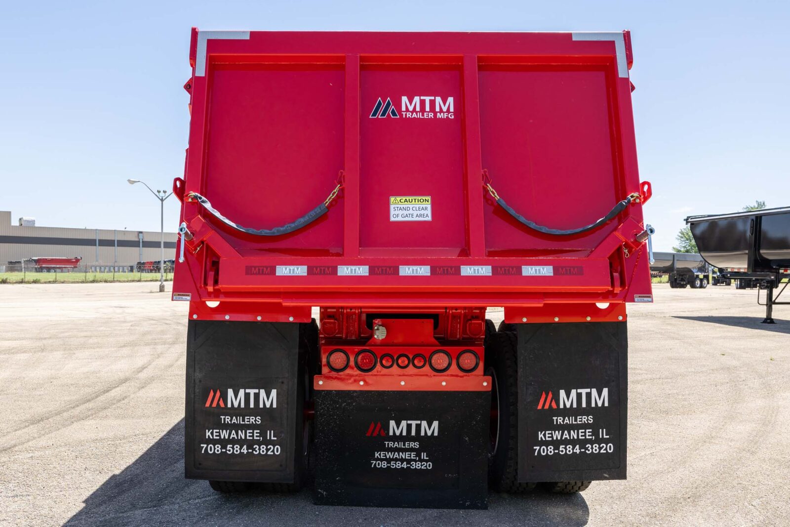 Red MTM quarter-frame end-dump trailer, view of the back