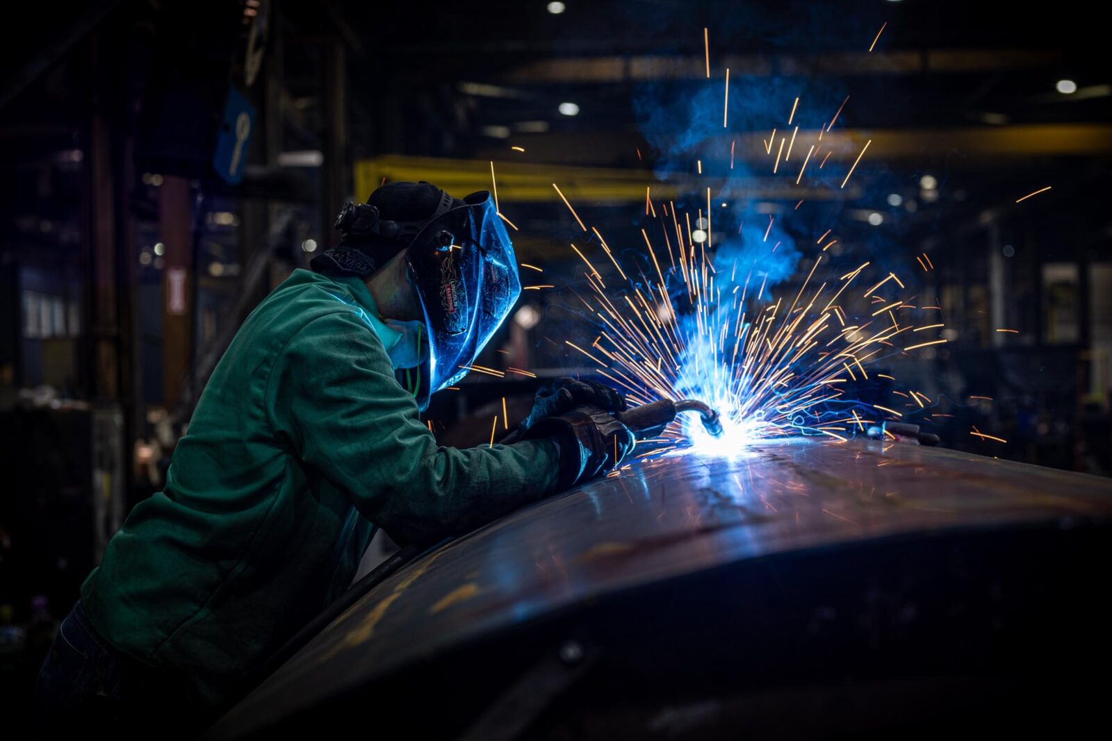 Person welding a trailer with sparks flying