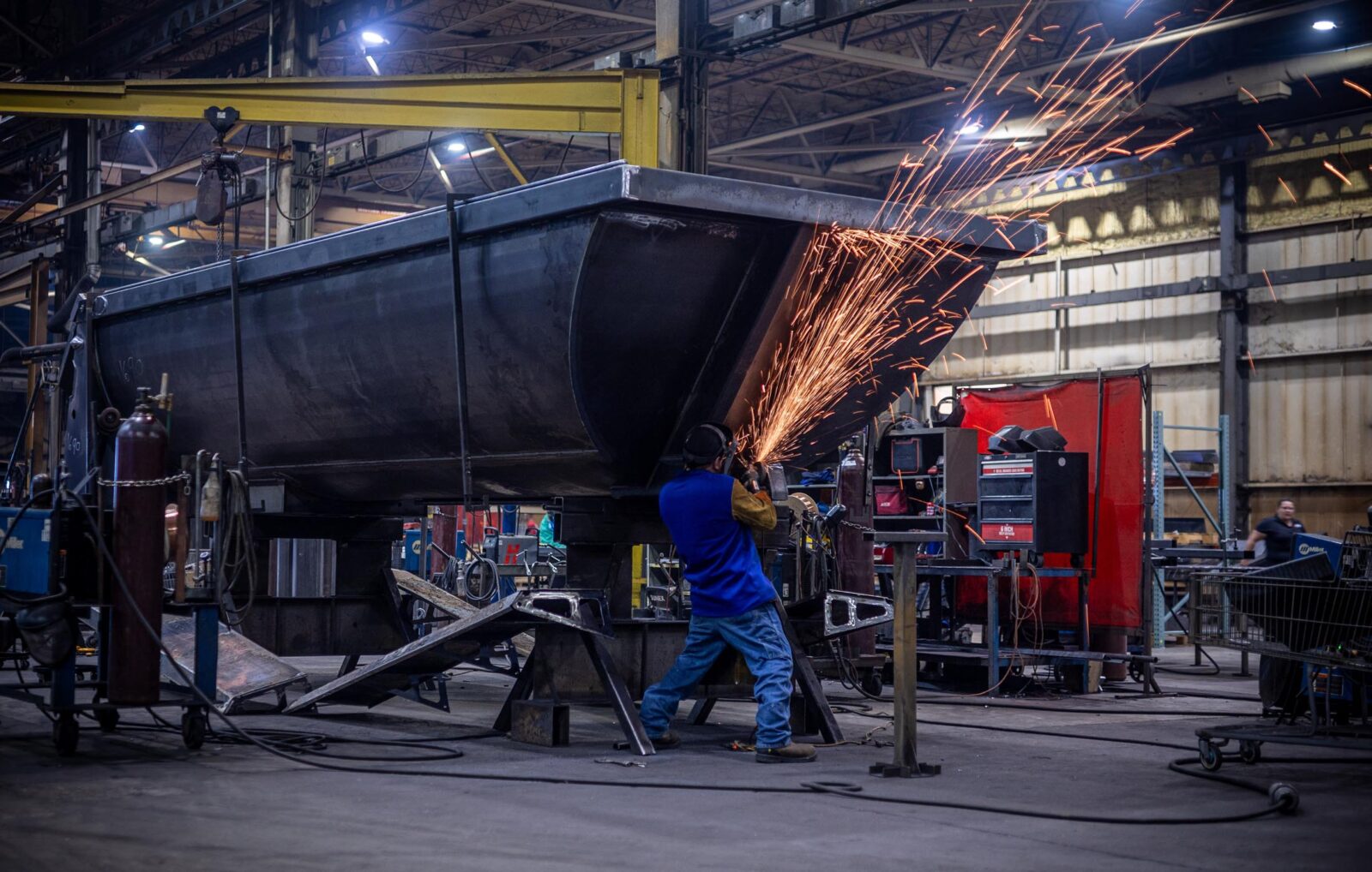 Man working on a dump trailer with sparks flying