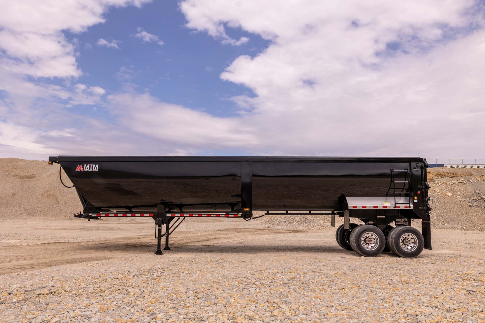 black 40' end-dump trailer in a quarry