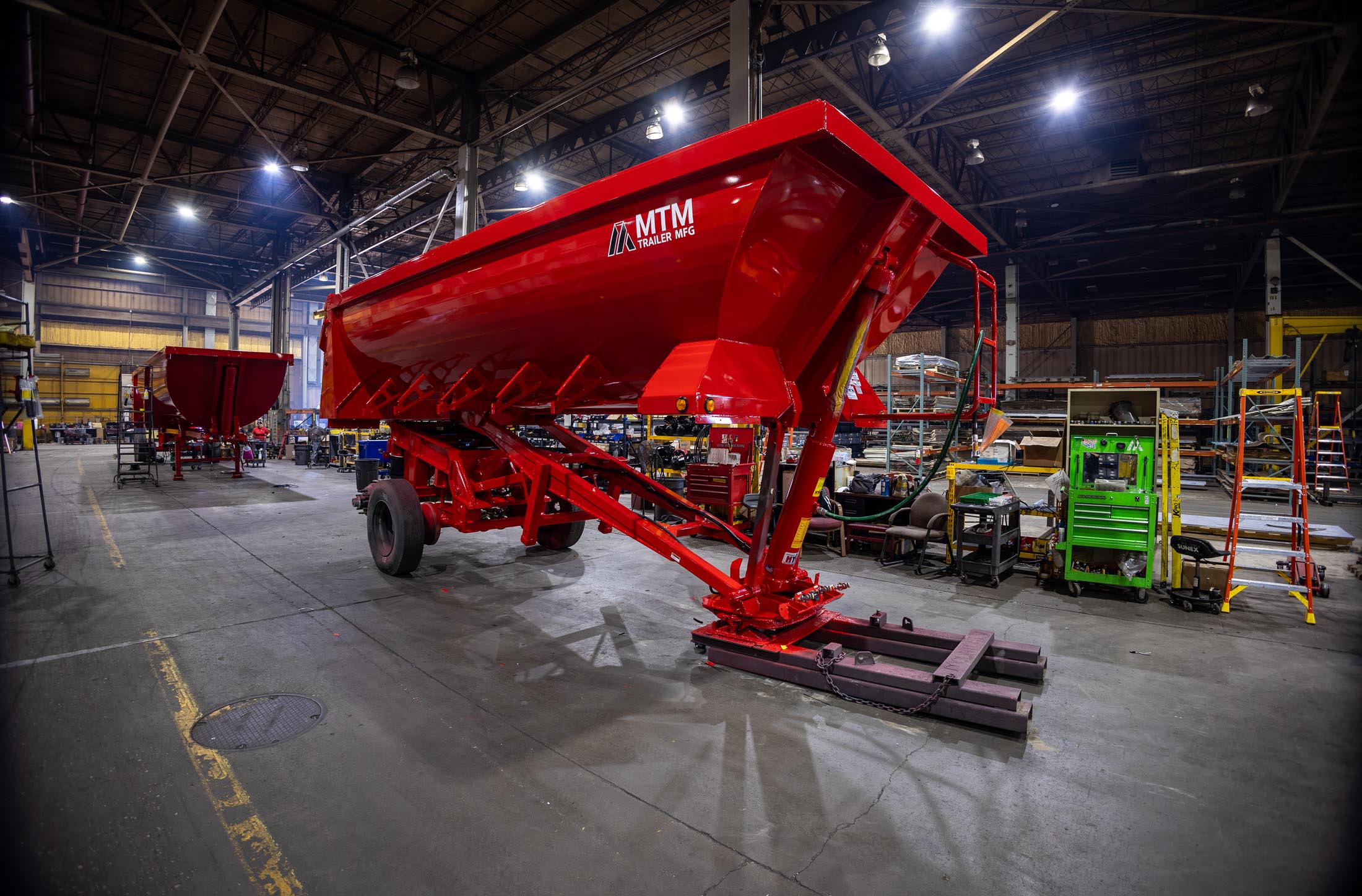 Red MTM quarter-frame end-dump trailer getting finishing touches in the factory