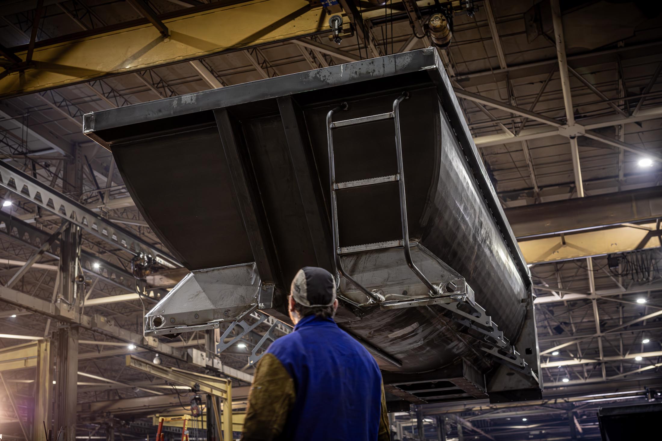 Trailer body raised in the air in the MTM factory with a man underneath