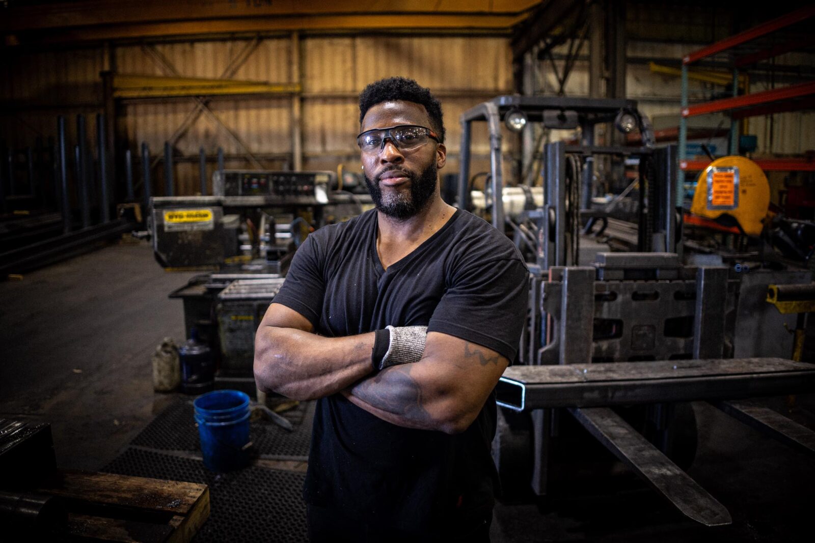 Man, looking proud, wearing safety glasses and standing in the MTM factory