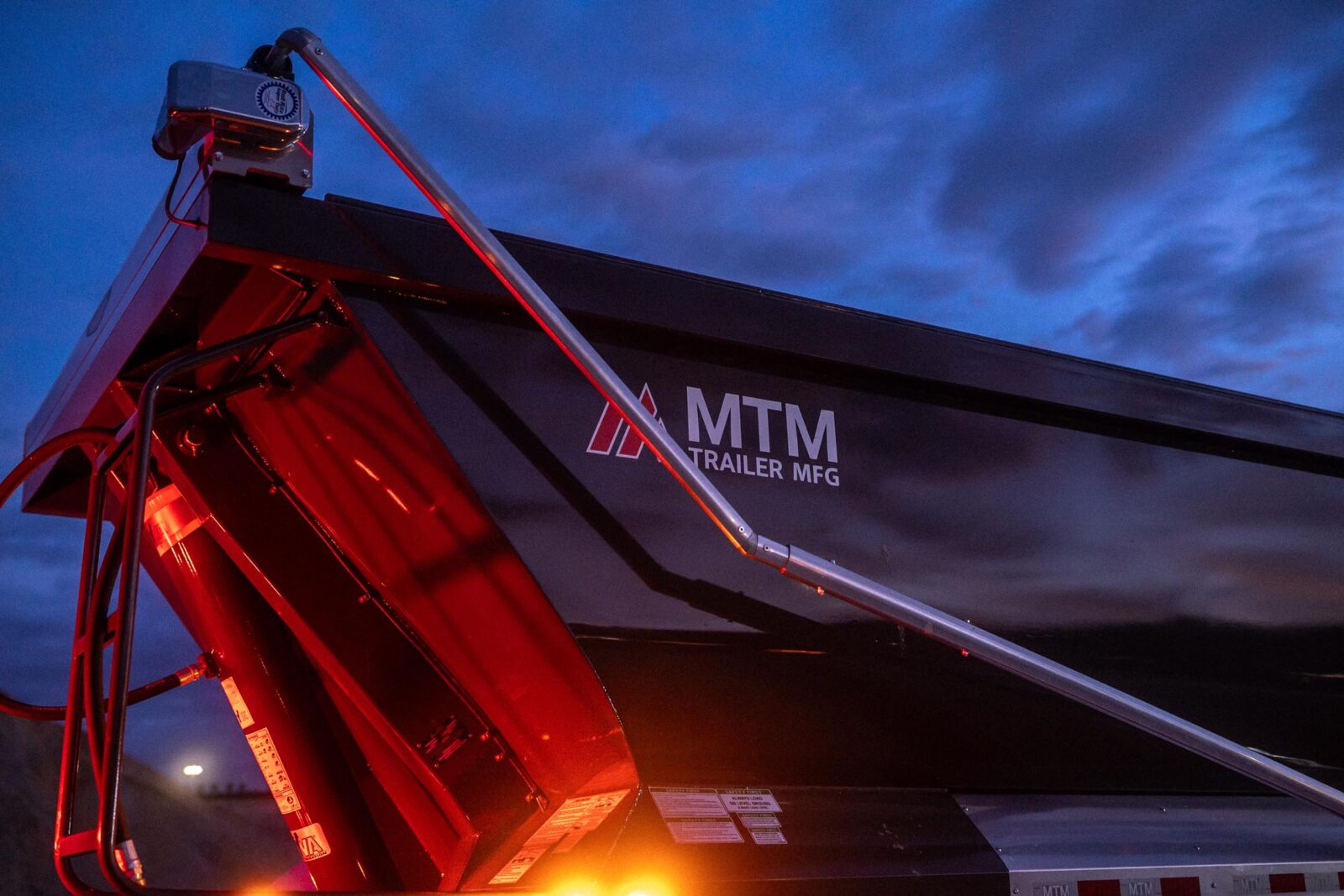 An MTM trailer with logo visible in the early morning light