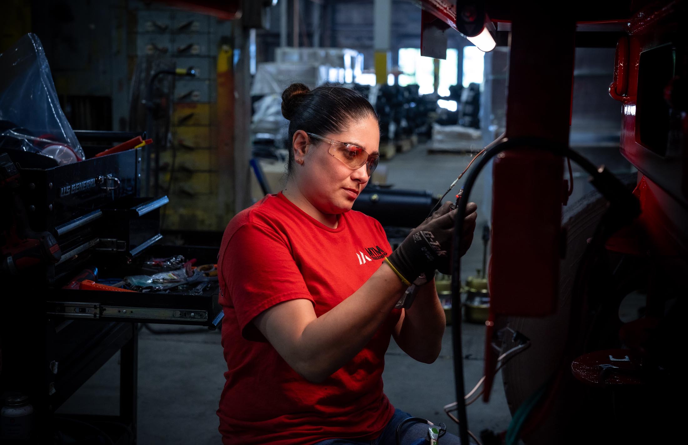 Woman working at MTM installs electrical wiring harness on a MTM Trailer