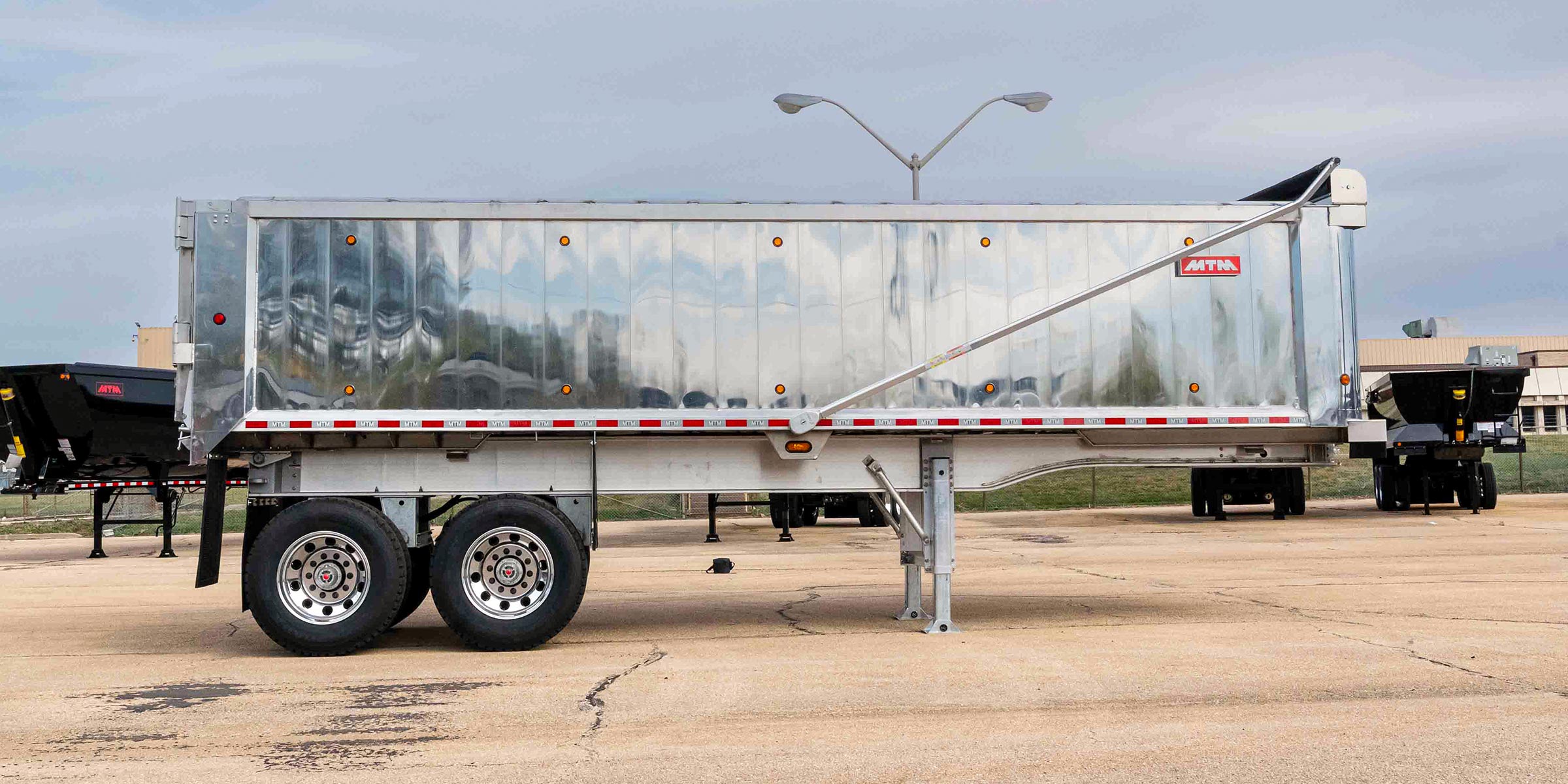 Side view of an MTM Aluminum Full Frame end-dump trailer
