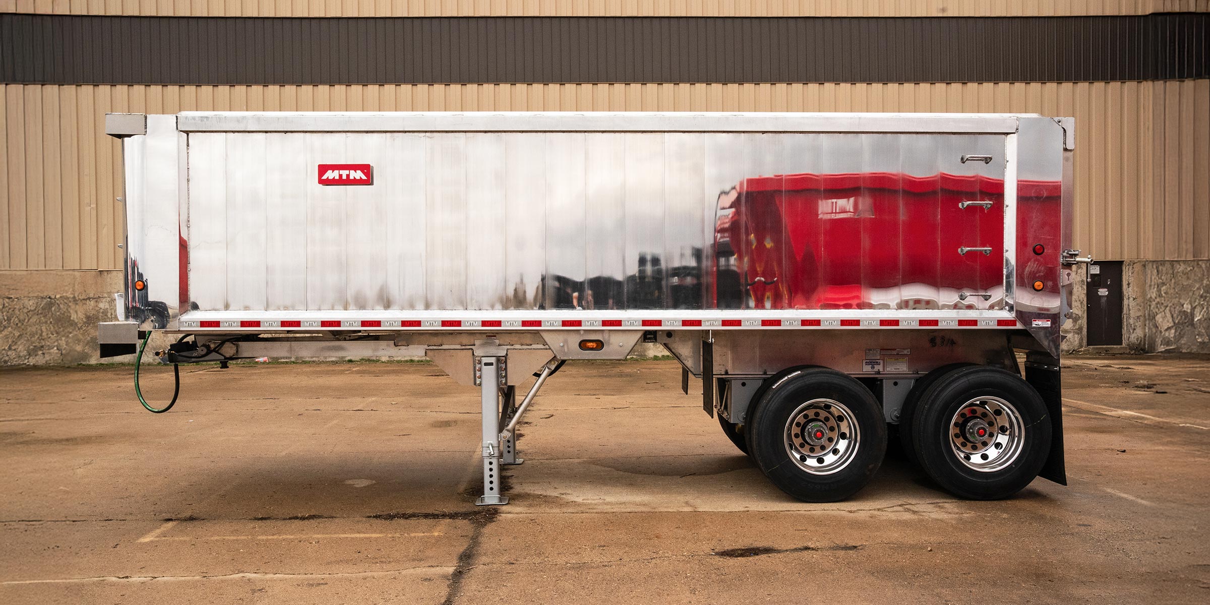 A side view of an MTM Short-Frame Aluminum End Dump Trailer